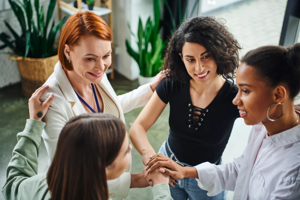 4 femmes confiante qui se regardent en se souriant