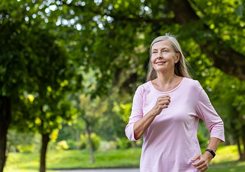 Femme âgée qui court en pleine foret